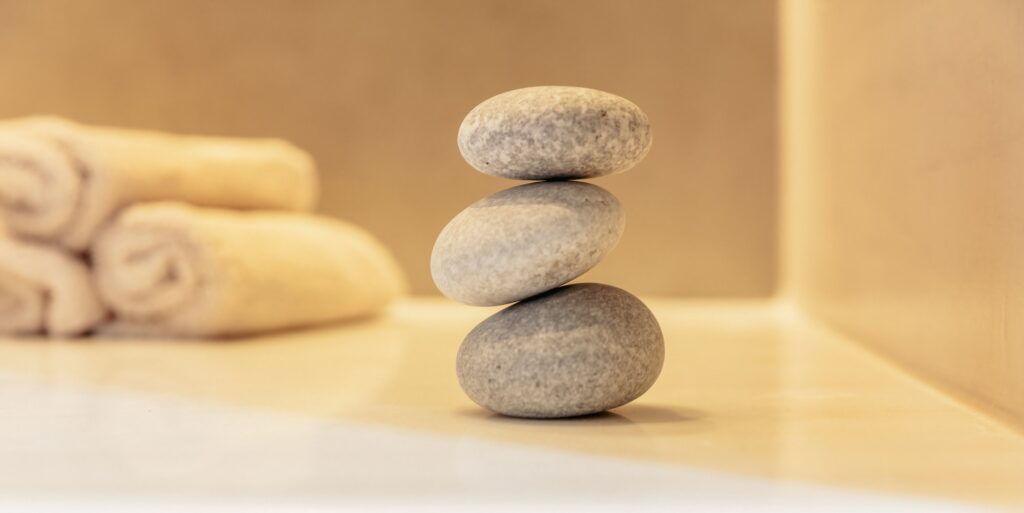 Zen stones, smooth pebbles pyramid stacked balance, spa interior background.